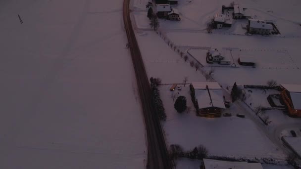 空中拍摄着覆盖着积雪的山城 日落时分蜿蜒穿过山谷的道路 — 图库视频影像