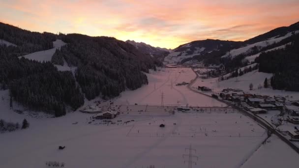 Flygfoto Snötäckt Bergsstad Slingrande Väg Genom Dalen Solnedgången — Stockvideo