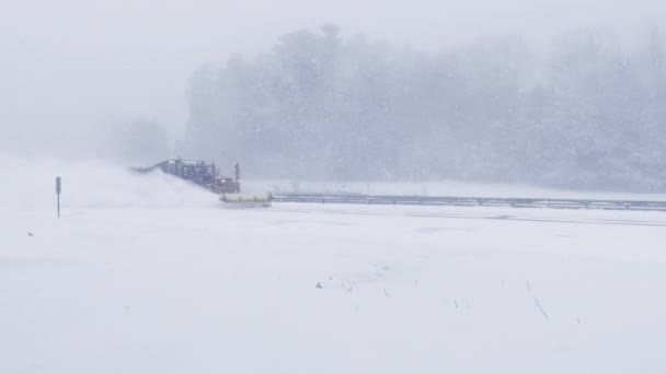 北東ブリザードの間に州間高速道路で雪を耕す冬の耕運機 — ストック動画