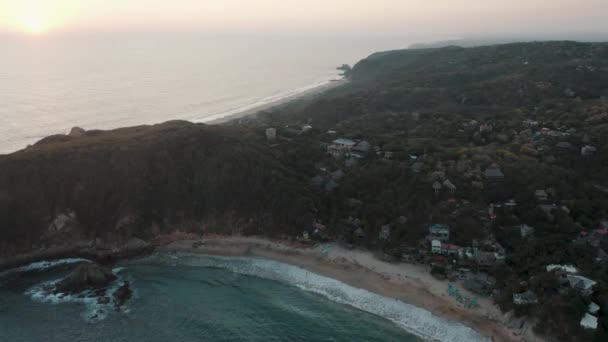 遠くの地平線の海の上に美しい夕日を眺めながら メキシコのオアハカ海岸のマズンテビーチの空中ドローンショット — ストック動画