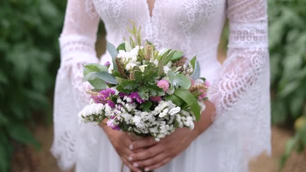 Noiva Bonita Segurando Buquê Flores Silvestres Mão Folhagem Exuberante Livre — Vídeo de Stock