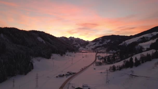 Flygfoto Snötäckt Bergsstad Slingrande Väg Genom Dalen Solnedgången — Stockvideo