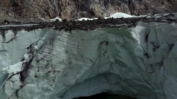 意大利阿尔卑斯山中的大冰川 上面有山洞 冰封的绿湖 冰面上有岩石 空中从底部到顶部都有冰雹 — 图库视频影像