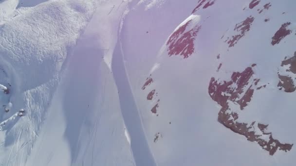空中俯瞰滑雪者 在阳光灿烂的阿尔卑斯山中滑下雪坡滑行 — 图库视频影像