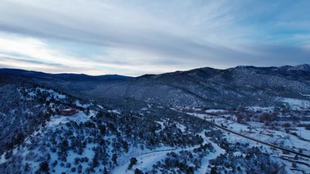 Drone Sköt Över Snöig Dal Med Några Hem Och Slingrande — Stockvideo