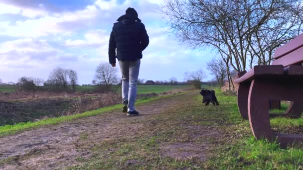 Muž Kráčí Svou Malou Černou Bolonkou Přírodě — Stock video