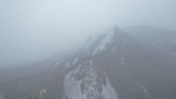 雪嵐のブリザードの間 コロラド州ボルダー近くの雪に覆われた山々に向かって飛行するドローンの空中映像 — ストック動画