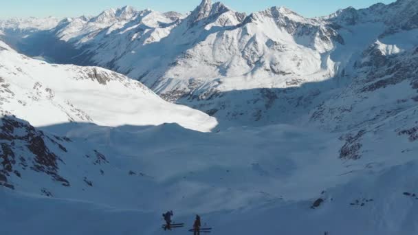 山の尾根の上のスキー 日当たりの良い アルプスの冬の日と山の上の空中の景色 引き戻す ドローンショット — ストック動画