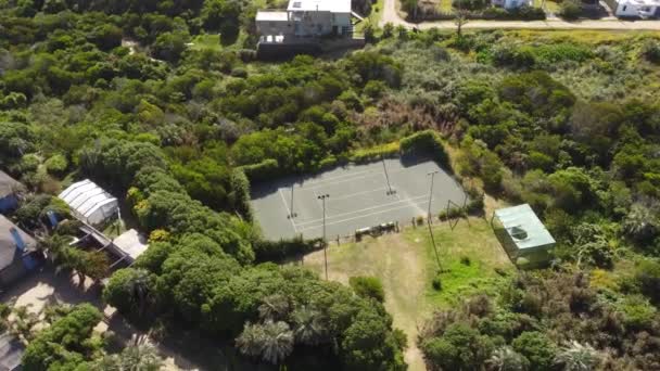 Aerial Orbit Shot Empty Tennis Court Surrounded Green Nature Sunlight — Vídeo de stock