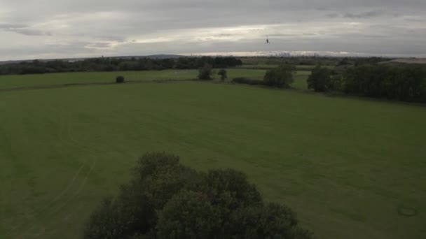 ジャイロコプターのドローンは茂みの上で上昇しますジャイロは遠くにロンドンのスカイラインを過ぎて飛ぶように — ストック動画