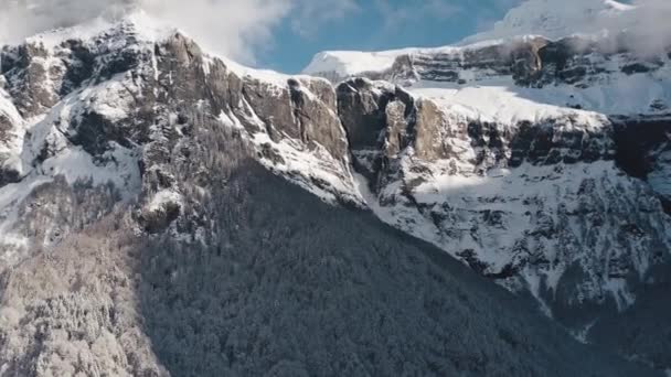 在寒冷的冬天 雪地覆盖在雪地里 空中俯瞰雪地 倾泻向马戏团的云峰 雪地从高高的悬崖峭壁上滑落下来 — 图库视频影像
