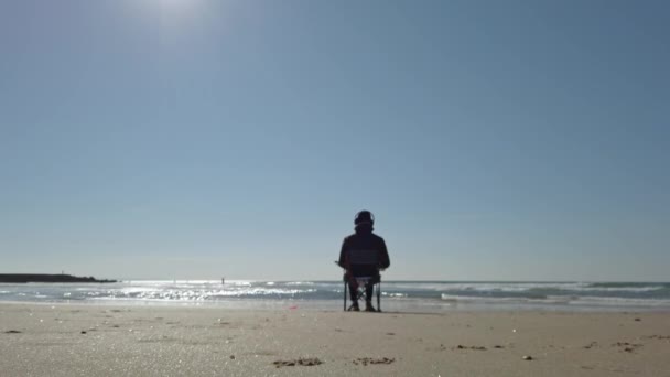 Pessoa Sentada Cadeira Praia Observando Ondas Pesca Vista Estática Para — Vídeo de Stock
