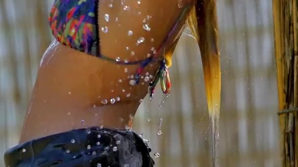 一个性感的黑发女模特儿穿着湿衣在野外的一个冲浪营洗澡 她的背后有一张详细的照片 — 图库视频影像