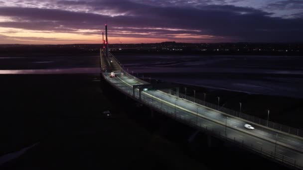 Mersey Gateway照明收费站在Mersey河宽轨道上紫色日出时跨越空中景观 — 图库视频影像