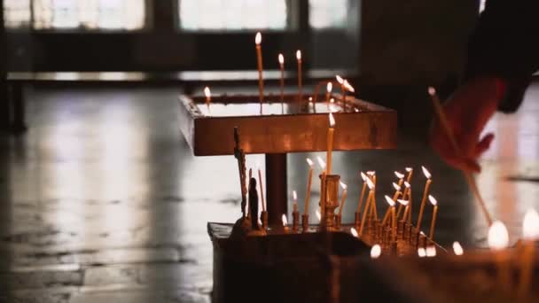 Fotografía Una Persona Colocando Una Vela Titular Una Iglesia Ortodoxa — Vídeo de stock