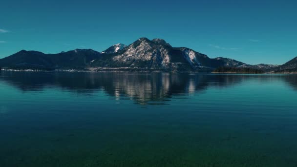 オーストリアに近いアルプス山脈の南ドイツの風光明媚なバイエルン湖Walchensee 冬の青い澄んだ水の波と牧歌的な青い空 シームレスビデオループシネマグラフ Uhd空撮ドローン — ストック動画