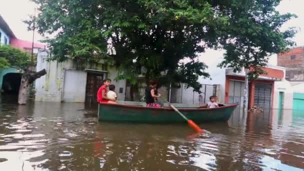 浸水した道路を漕ぎ出す小さなボートの家族 — ストック動画