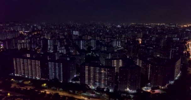 呼啸的公寓楼的空中景观在夜间被点亮 带有新城市感的紫色色调图像 — 图库视频影像