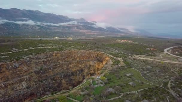 前景に旧鉱山 背景にカラフルな曇り空の美しい山の風景とクロアチアの風景の広い空中ショット — ストック動画