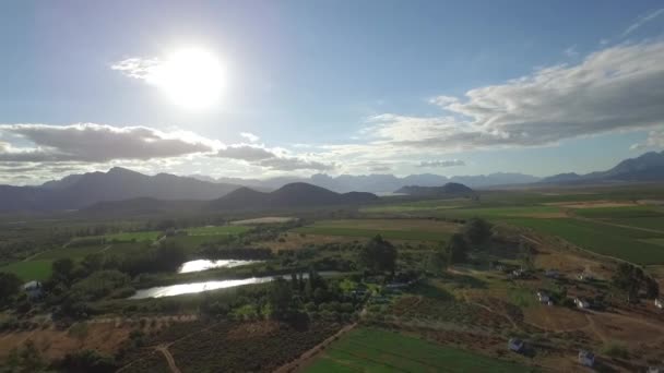 아프리카의 농지와 포도원 천천히 상승하는 구름에서 태양이 치솟는 장면이다 — 비디오