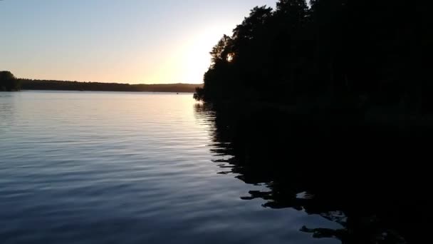 Über Das Wasser Schweben Den Sonnenuntergang Durch Die Bäume Beobachten — Stockvideo