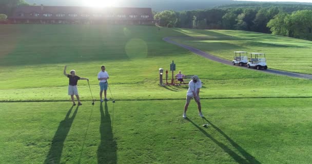 Şapkalı Bir Adam Golf Sopasını Sallarken Kamera Yükselir Ormanlık Alanlarla — Stok video