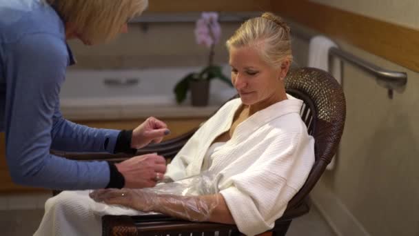 Dojrzała Blondynka Siedząca Krześle Spa Terapeutka Zdejmująca Rękawiczki Rąk Zabiegu — Wideo stockowe