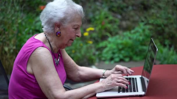 Zdjęcie Boczne Starszej Kobiety Piszącej Klawiaturze Przy Stole Ogrodzie — Wideo stockowe