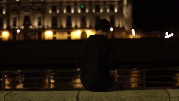 Junger Mann Sitzt Allein Auf Einer Mauer Der Straße Neben — Stockvideo
