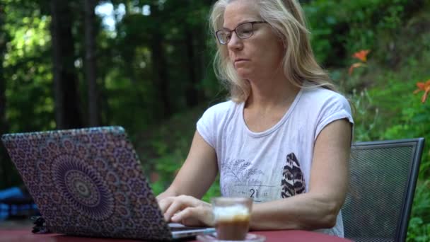 Focus Van Koffie Naast Een Mooie Volwassen Vrouwen Laptop Een — Stockvideo