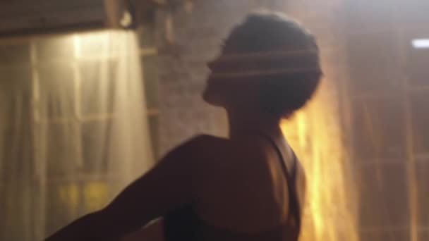 手紧握着一个年轻的黑发女子的近照 她流过了武士的倒转序列 上半身的细节 灰暗的砖墙上背景上的橙色霓虹灯 — 图库视频影像