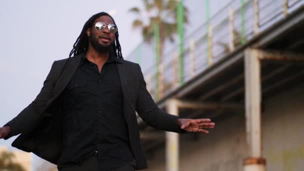 Schwarzer Sänger mit Soul, Hip Hop, Reggae, Rhythm and Blues, Liebeslied für ein Musikvideo im Freien neben Brücke.