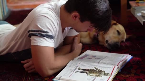 Adolescente Niño Estudiando Historia Libro Texto Suelo Con Perro Durmiendo — Vídeos de Stock