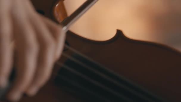 バイオリニストの顔にカメラが傾きながら演奏されているバイオリンの美しい極端なクローズアップショット — ストック動画