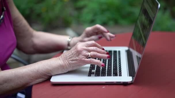 Yaşlı Kadınların Elleri Dışarıda Bahçede Dizüstü Bilgisayarda Klavyeyle Yazı Yazarken — Stok video