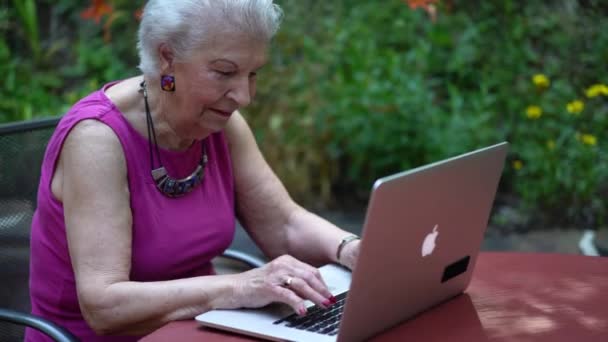 Mujer Madura Sonriendo Escribiendo Teclado Del Ordenador Portátil Fuera Patio — Vídeos de Stock