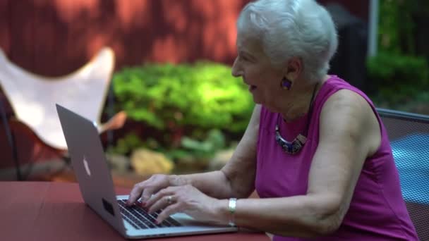 Idős Nevet Ahogy Gépel Laptop Billentyűzeten Kívül Reggeli Fényben — Stock videók