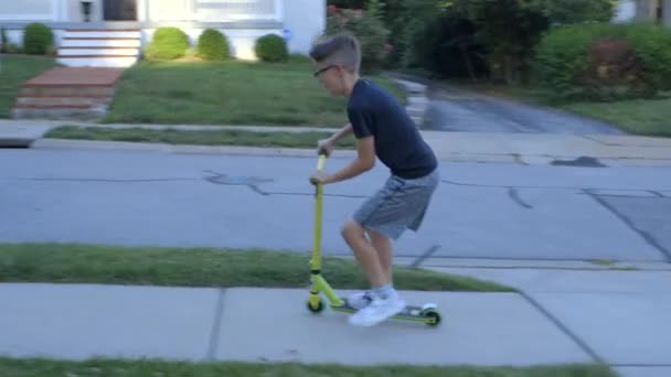 Tween Muchacho Monta Scooter Encima Acera Entrada Casa Los Suburbios — Vídeo de stock