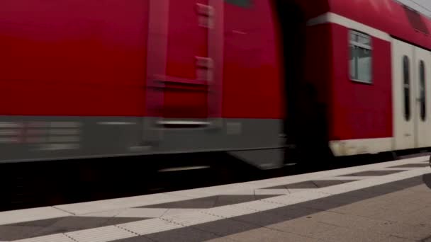 德国某火车站一列固定的灰色火车驶过红色的火车 — 图库视频影像
