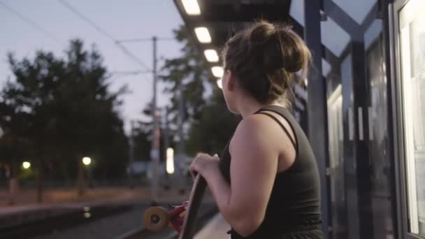 若いです女の子とともにLongboard待っていますのためにザ路面電車でザEvig — ストック動画