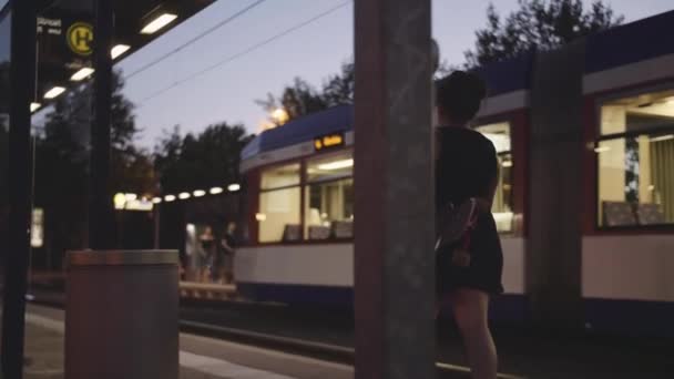 Jong Meisje Met Longboard Wachten Voor Tram Evenig — Stockvideo