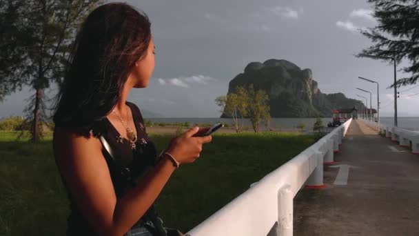 Aranyos Ázsiai Lány Mobiltelefont Használ Mosolyog Mólón Gyönyörű Fiatal Lány — Stock videók