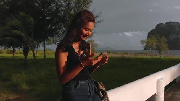 Χαριτωμένη Ασιάτισσα Χρησιμοποιεί Ένα Κινητό Τηλέφωνο Χαμογελώντας Στην Προβλήτα Όμορφο — Αρχείο Βίντεο