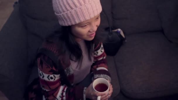 Ασιάτισσα Που Κάθεται Στον Καναπέ Πίνοντας Τσάι Και Κουβεντιάζοντας — Αρχείο Βίντεο