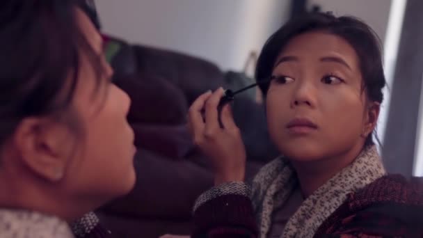 Asijské dívka dávat na řasenku v zrcadle