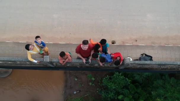 Pokazuję Bandzie Dzieciaków Jak Działa Mój Dron Stojąc Moście Laosie — Wideo stockowe