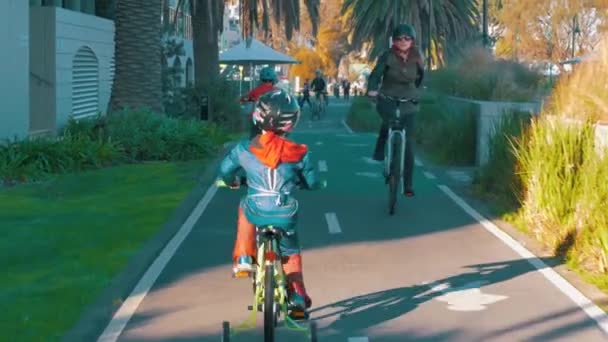 在圣基尔达 孩子们骑着自行车走在自行车道上 一个孩子穿着蜘蛛人的服装 — 图库视频影像