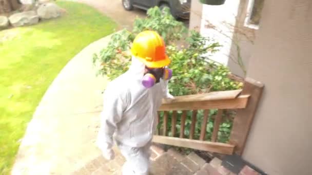 身穿白色防护服的工人走进装有石棉的房子 — 图库视频影像