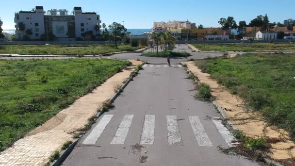 Motociclista Scooter Elétrico Cruzeiro Por Uma Estrada Abandonada Crescida — Vídeo de Stock