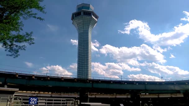 芝加哥奥黑尔机场空中交通管制塔 Atc Tower 在明亮的阳光下 云层从后面经过 地铁从前面经过 城市环境 — 图库视频影像